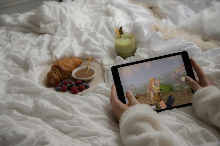 Enjoy a cozy morning in bed with a croissant, berries, matcha latte, and a tablet game.